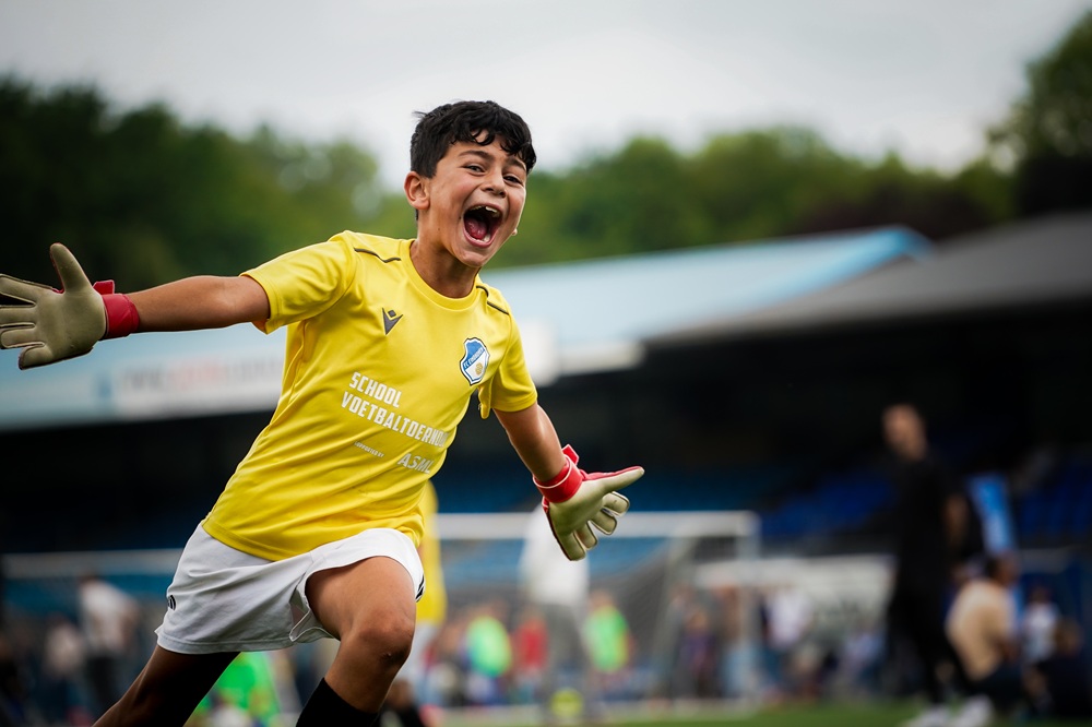 Schoolteams en publiek op het veld tijdens het ASML Schoolvoetbaltoernooi van FC Eindhoven